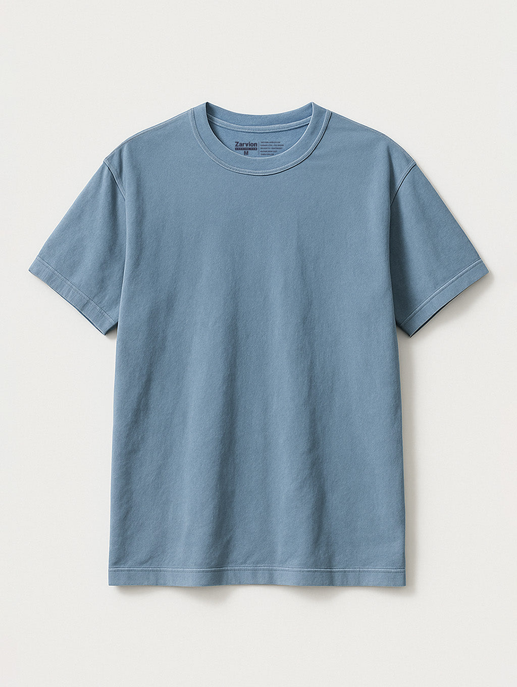 Flat lay of Worn Denim Blue vintage tee by Zarvion – relaxed fit short-sleeve t-shirt on light gray background