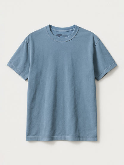 Flat lay of Worn Denim Blue vintage tee by Zarvion – relaxed fit short-sleeve t-shirt on light gray background