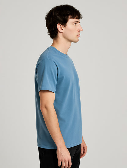 Side profile of male model wearing Worn Denim Blue vintage t-shirt by Zarvion – clean silhouette and soft drape